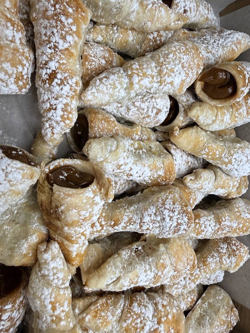 Peruvian cachitos filled with dulce de leche and dusted with powdered sugar by Cakes by Steph